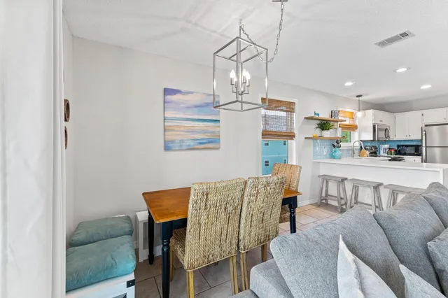 a living room with kitchen island furniture and a chandelier