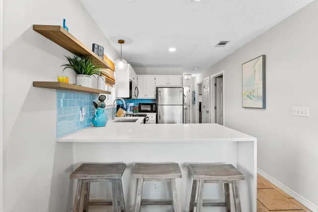 a kitchen with kitchen island a stove a sink and a refrigerator