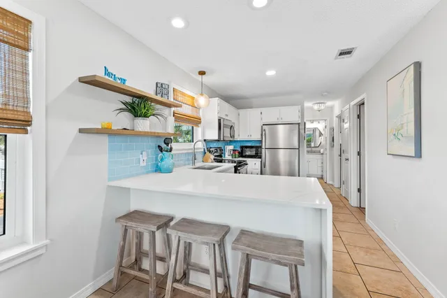 a kitchen with stainless steel appliances granite countertop a refrigerator and a stove top oven