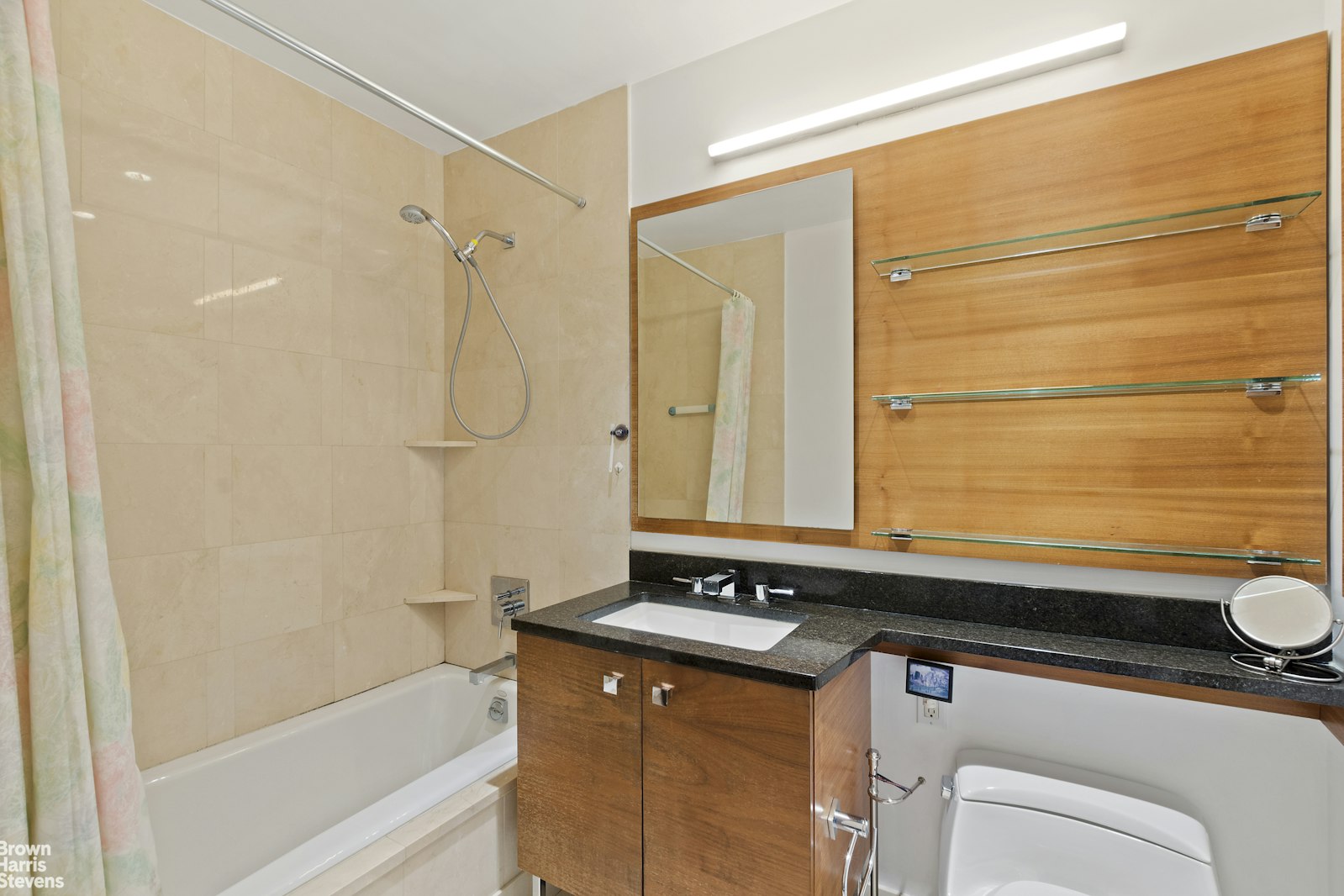 120 Riverside Boulevard, Unit 7H Manhattan, NY 10069 - Photo 5 of 6 a bathroom with a granite countertop sink a toilet and shower