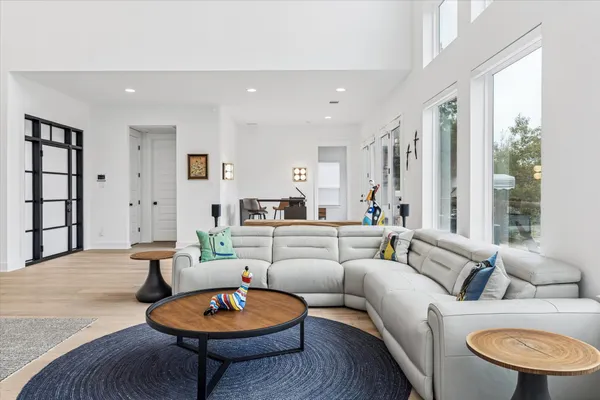 a living room with furniture a rug a lamp and a large window