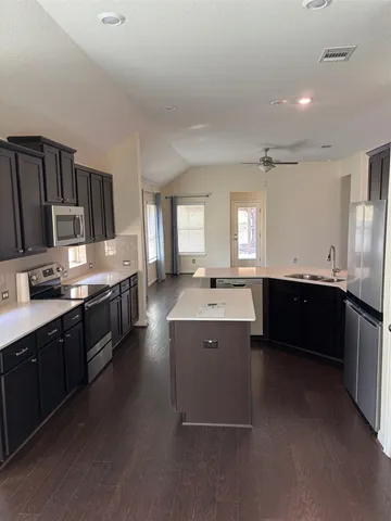 a large kitchen with a large counter top appliances and cabinets