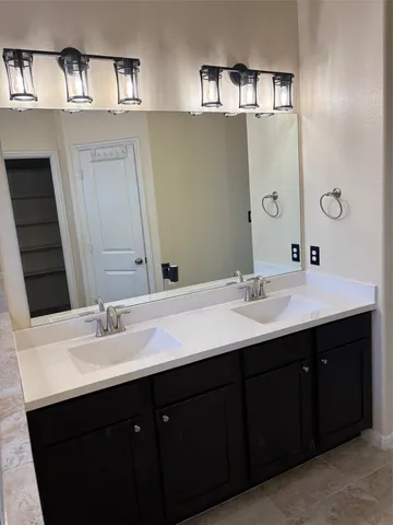 a bathroom with a double vanity sink and a mirror