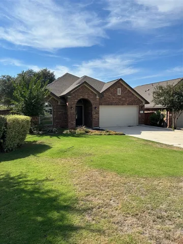 a front view of a house with yard and green space