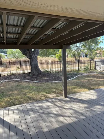 a backyard of a house with table and chairs under an umbrella