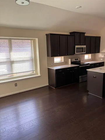 a kitchen with stainless steel appliances wooden cabinets and a stove top oven
