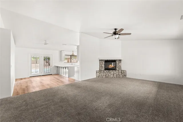 an empty room with windows and ceiling fan