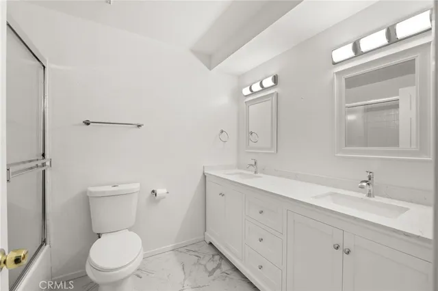 a bathroom with a toilet a sink a mirror and vanity
