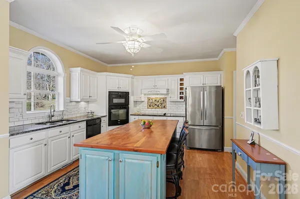 a kitchen with stainless steel appliances granite countertop a refrigerator and a stove top oven