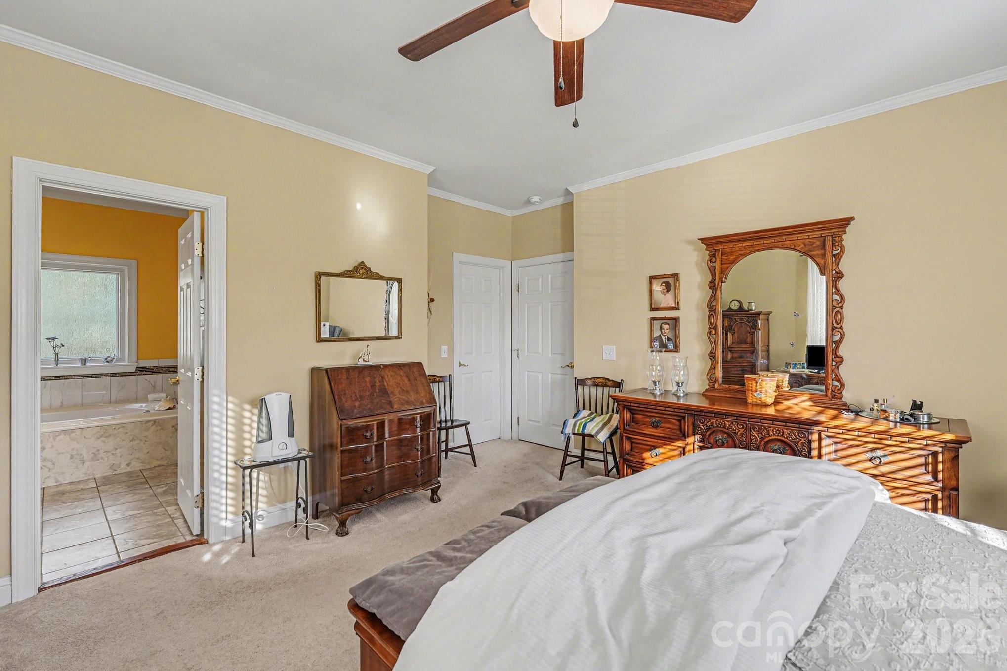 212 Pine Valley Road Mocksville, NC 27028 - Photo 13 of 28 a bedroom with a bed and a chandelier