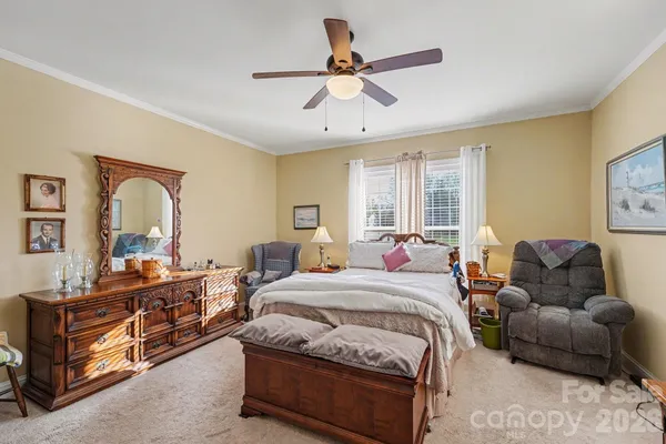 a bedroom with bed couch and window