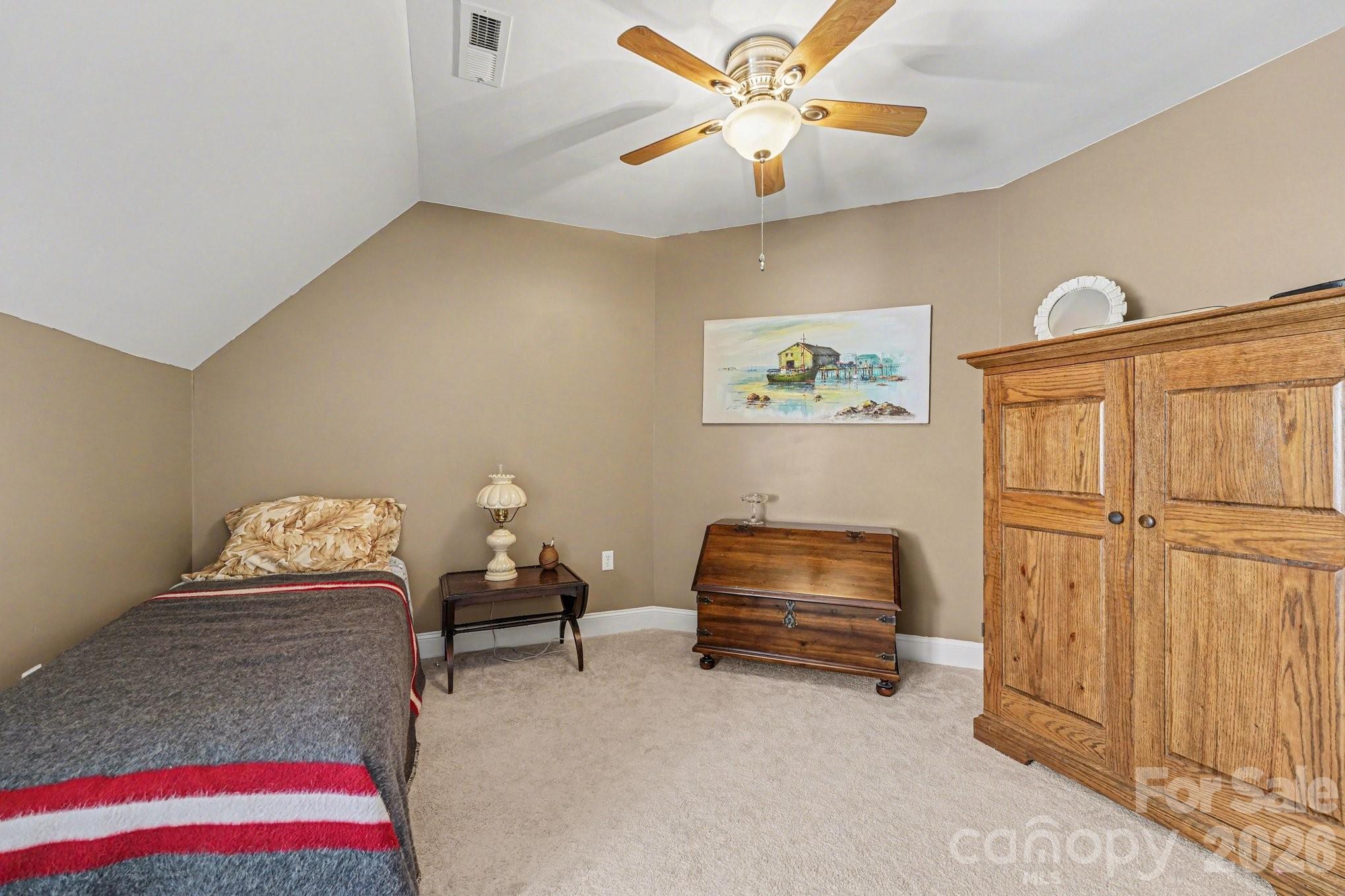 212 Pine Valley Road Mocksville, NC 27028 - Photo 22 of 28 a bedroom with furniture and a chandelier