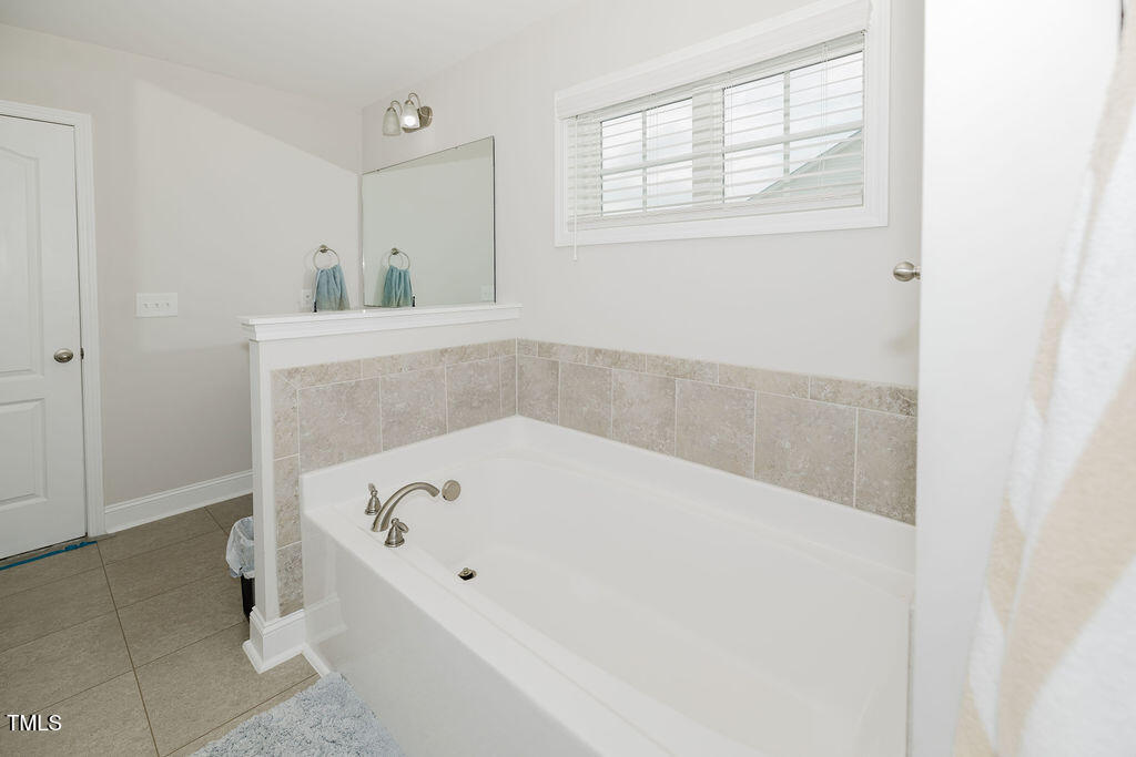 105 Perignon Drive Princeton, NC 27569 - Photo 25 of 38 a bathroom with a tub and mirror