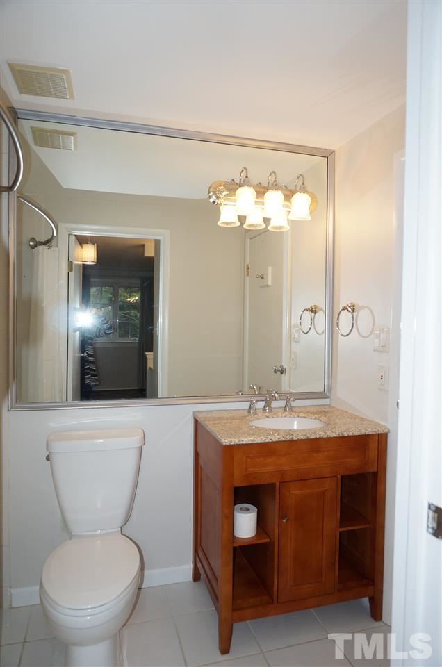 7700 Ohmann Court Raleigh, NC 27615 - Photo 12 of 20 a bathroom with a toilet a sink and mirror