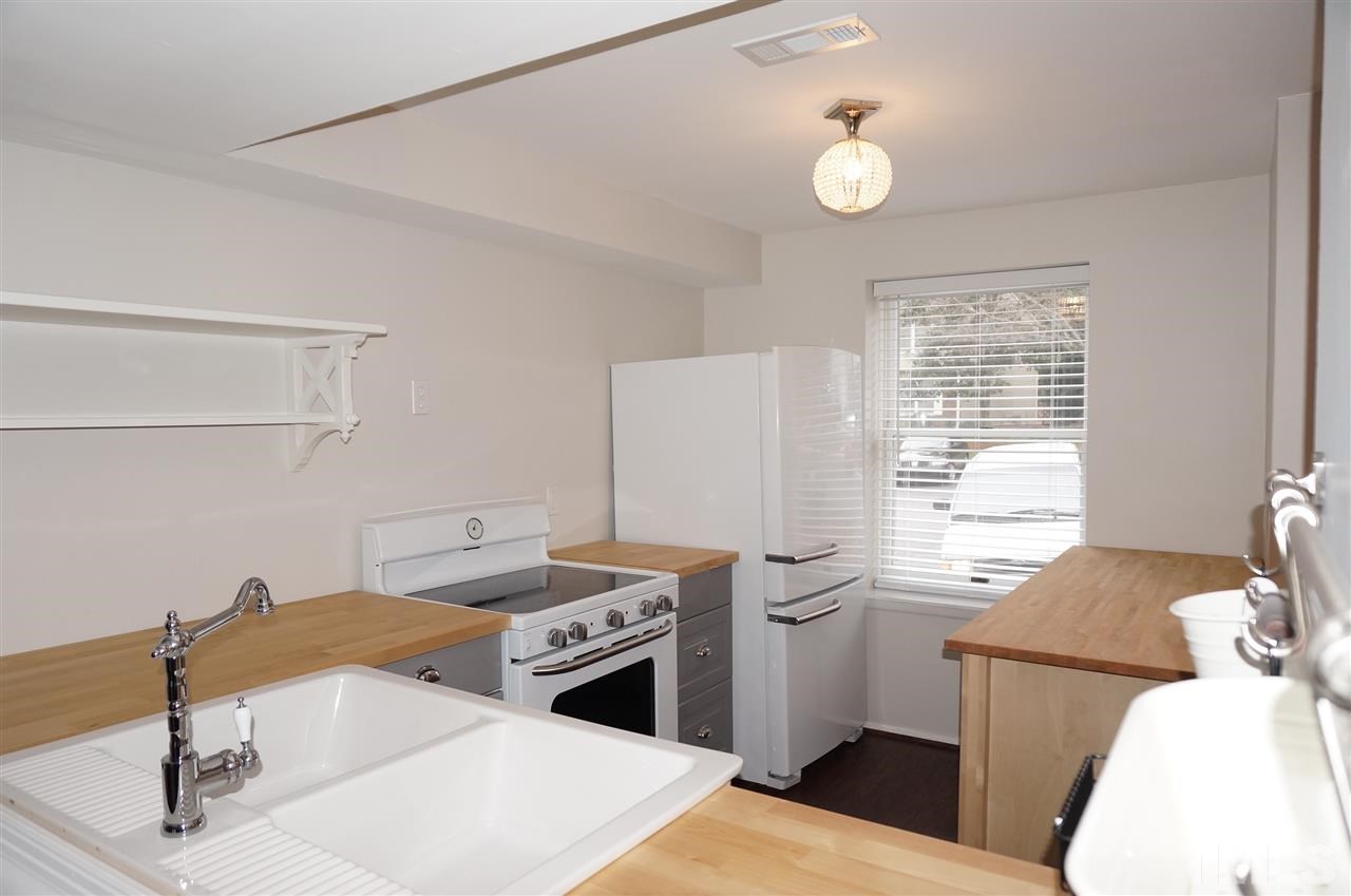 7700 Ohmann Court Raleigh, NC 27615 - Photo 3 of 20 a kitchen with a sink appliances and cabinets