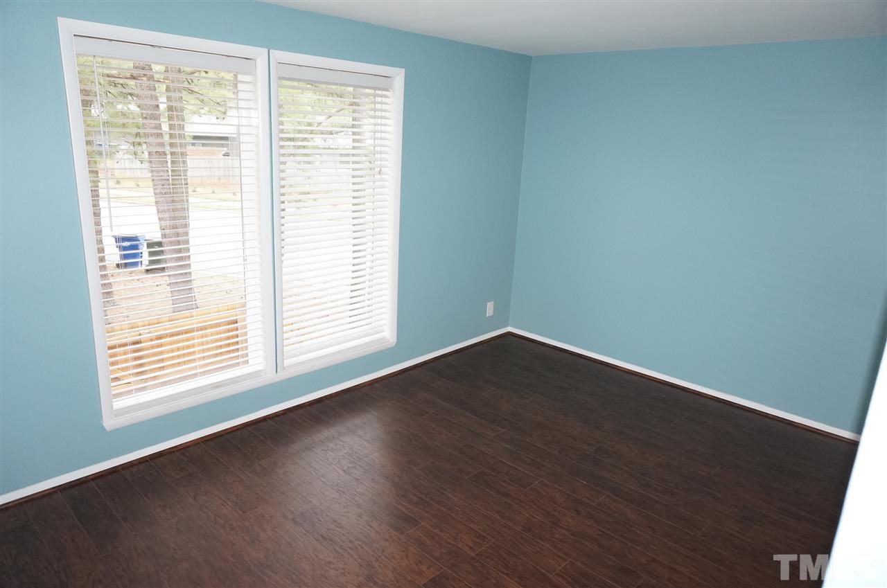 7700 Ohmann Court Raleigh, NC 27615 - Photo 10 of 20 an empty room with wooden floor and windows