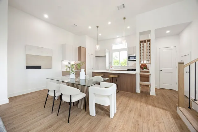 a kitchen with a table chairs refrigerator and microwave