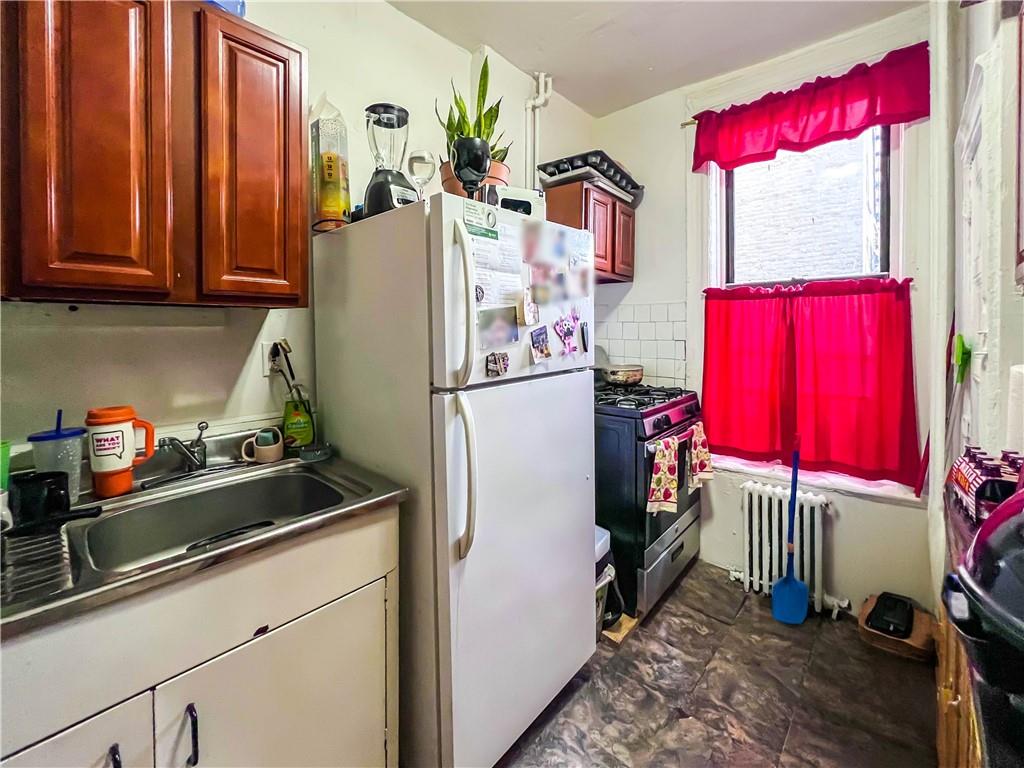 5907 4th Avenue Brooklyn, NY 11220 - Photo 11 of 37 a kitchen with stainless steel appliances granite countertop a refrigerator and a sink