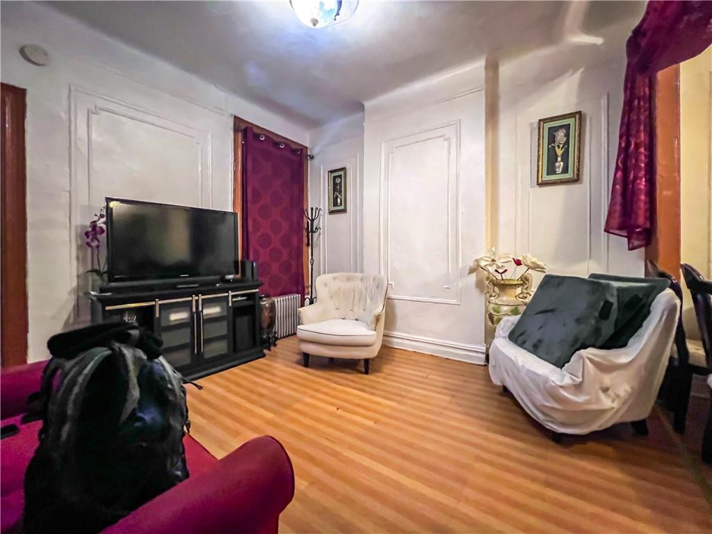 5907 4th Avenue Brooklyn, NY 11220 - Photo 30 of 37 a living room with furniture and a flat screen tv