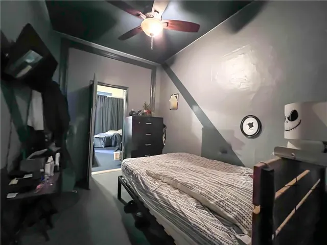 a bedroom with bed and a large window