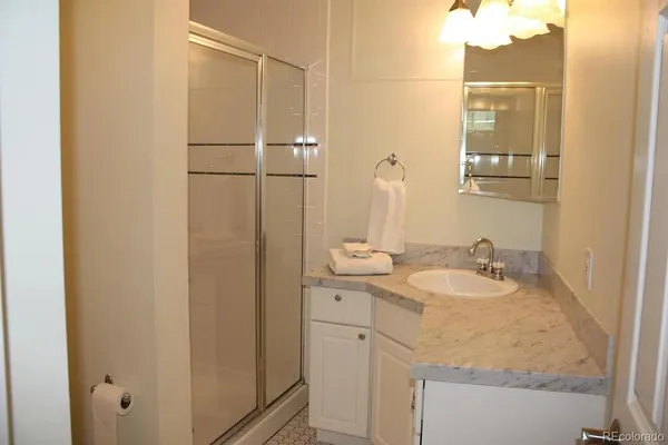 a bathroom with a granite countertop sink and a mirror