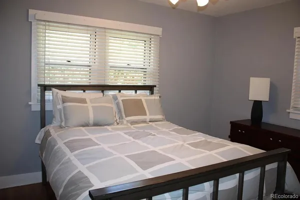 a bedroom with a bed table and window