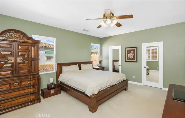 a bed sitting in a spacious bedroom next to a window