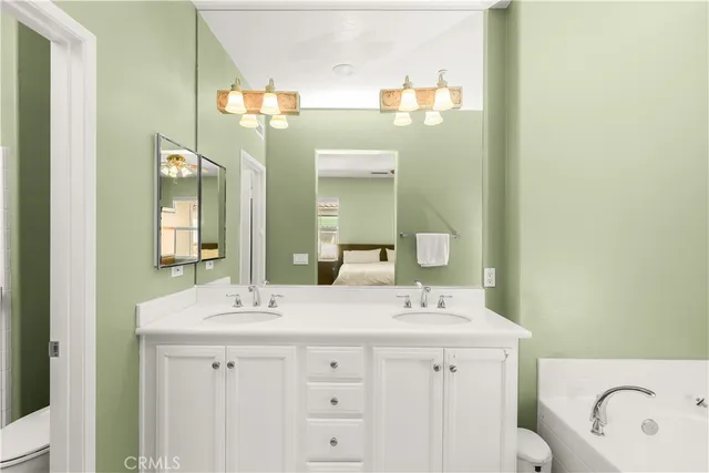 a bathroom with a double vanity sink mirror and bathtub