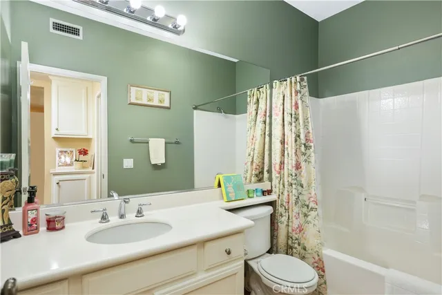 a bathroom with a sink vanity mirror and toilet
