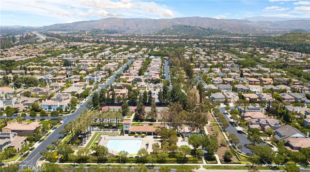 an aerial view of residential houses with outdoor space and trees