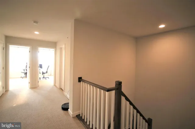 a view of a hallway view with wooden floor and a bathroom