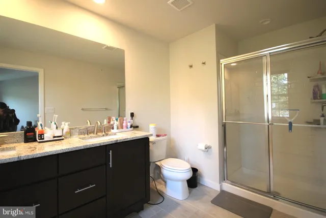 a bathroom with a double vanity sink toilet and shower
