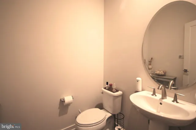 a bathroom with a sink a toilet and mirror