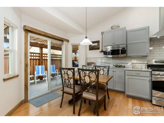 a kitchen with stainless steel appliances a dining table chairs and a refrigerator