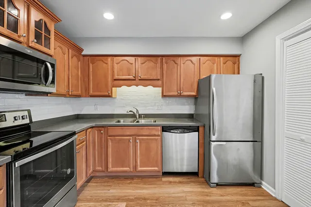 a kitchen with stainless steel appliances granite countertop a refrigerator a stove a sink and a microwave