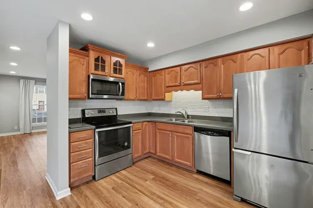 a kitchen with stainless steel appliances granite countertop a refrigerator stove microwave and sink