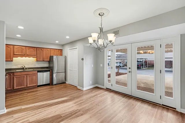 a view of a kitchen with stainless steel appliances granite countertop a refrigerator and a wooden floor