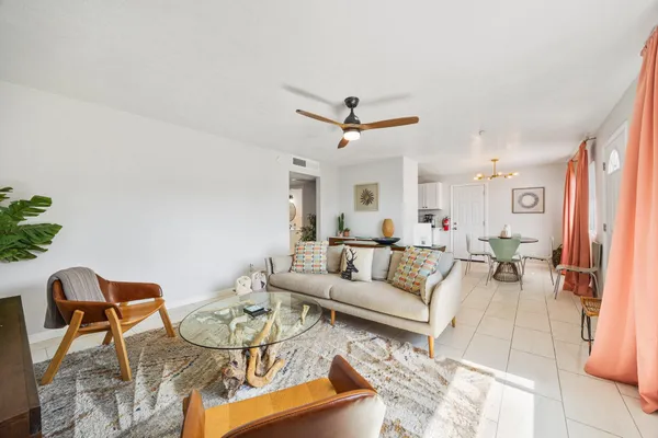 a living room with furniture a ceiling fan and a rug