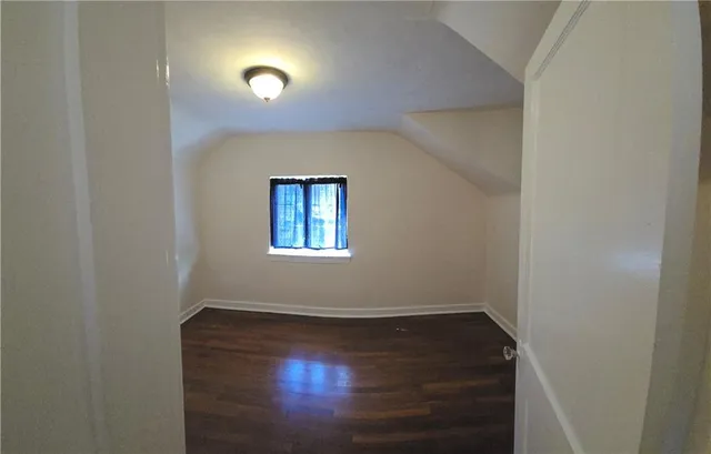 an empty room with wooden floor ceiling fan and windows