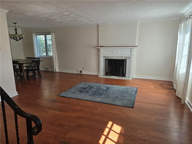 a view of a livingroom with wooden floor and staircase
