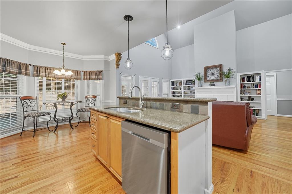 5090 Eubanks Road Woodstock, GA 30188 - Photo 13 of 54 a open kitchen with stainless steel appliances granite countertop a kitchen island a stove and a living room view