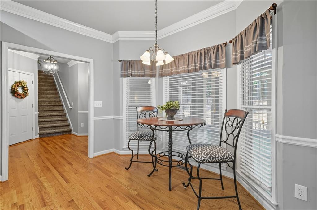 5090 Eubanks Road Woodstock, GA 30188 - Photo 15 of 54 a dining room with furniture a chandelier and wooden floor