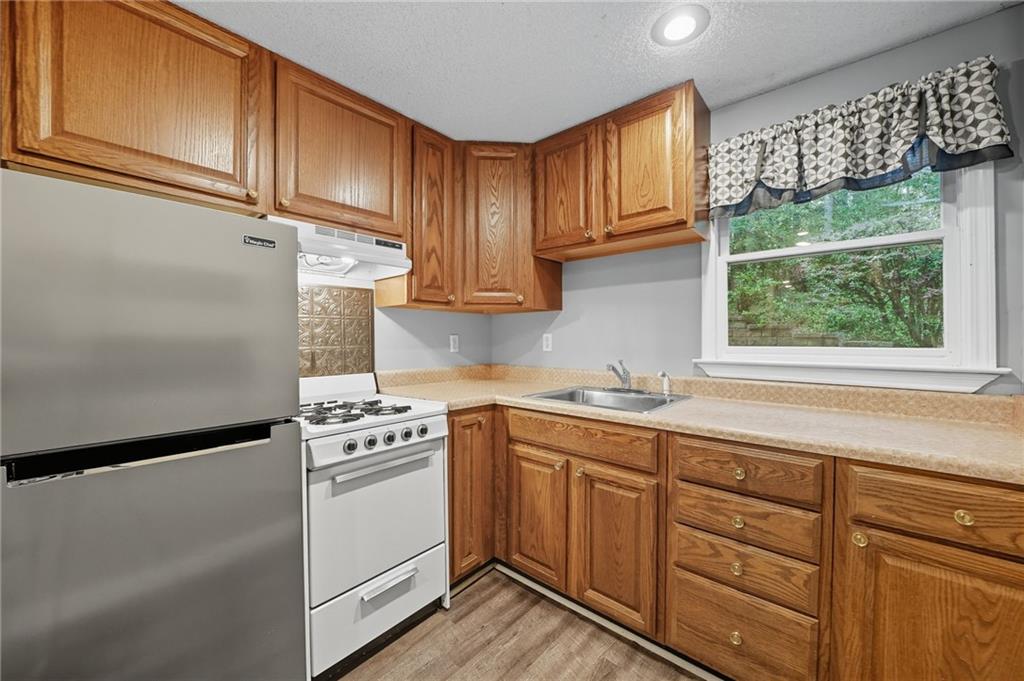 5090 Eubanks Road Woodstock, GA 30188 - Photo 38 of 54 a kitchen with stainless steel appliances granite countertop a sink a stove and a refrigerator