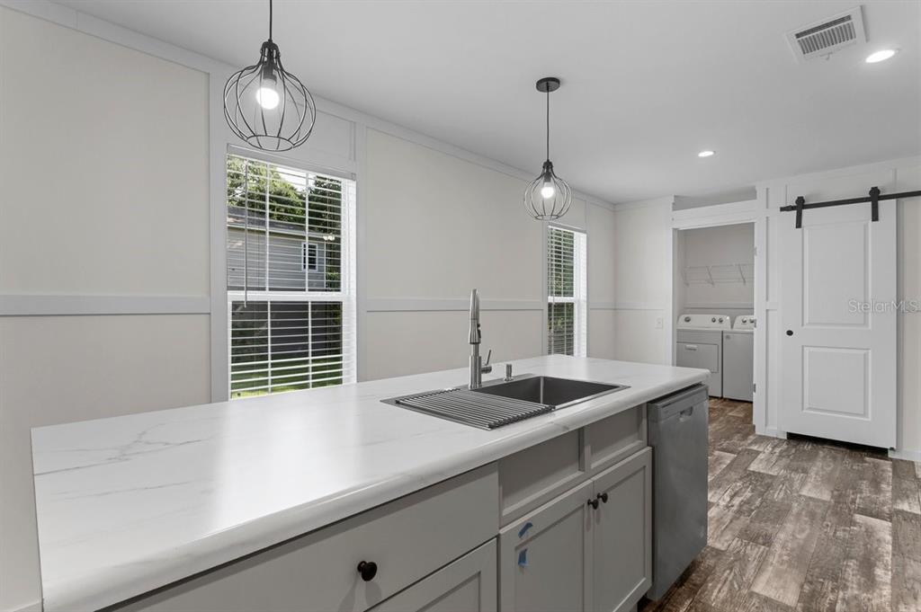 811 North Swindell Avenue, Unit 2 Lakeland, FL 33815 - Photo 6 of 33 a kitchen with granite countertop a sink a center island stainless steel appliances and cabinets