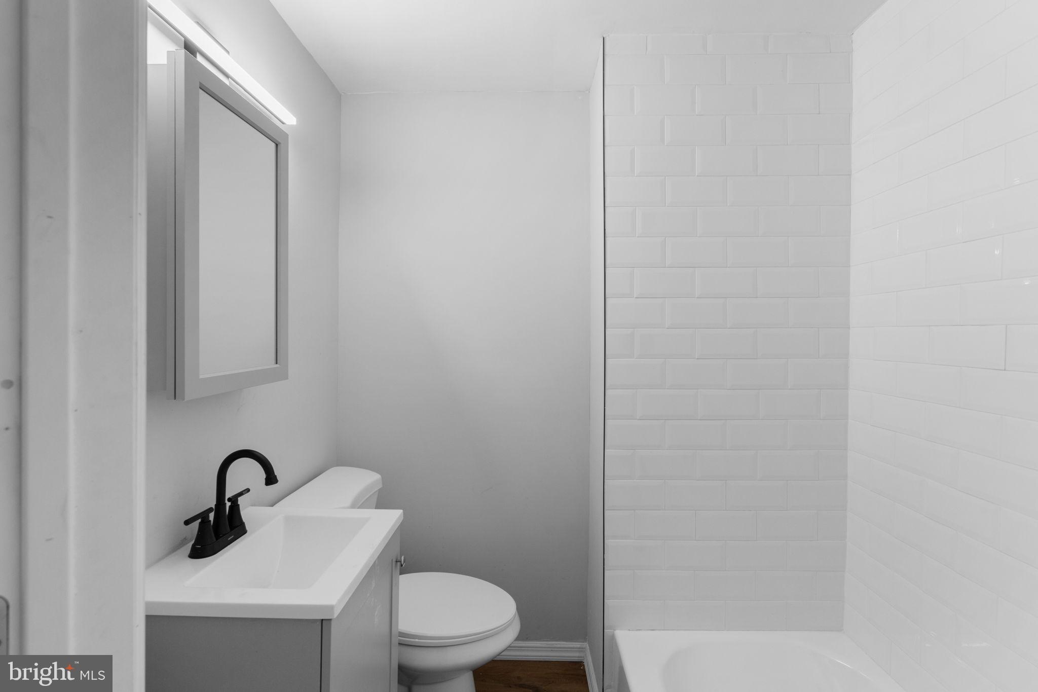 1020 Potter Street Chester, PA 19013 - Photo 14 of 26 a bathroom with a sink a toilet and mirror
