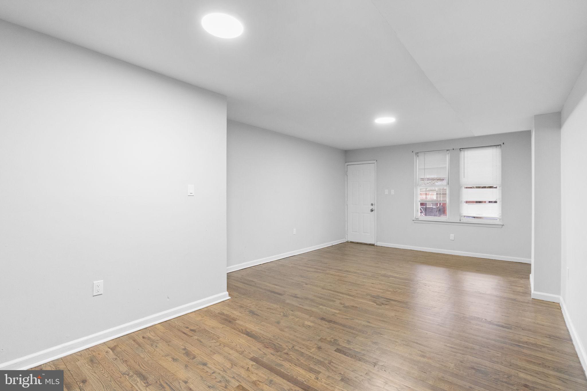 1020 Potter Street Chester, PA 19013 - Photo 5 of 26 an empty room with wooden floor and windows