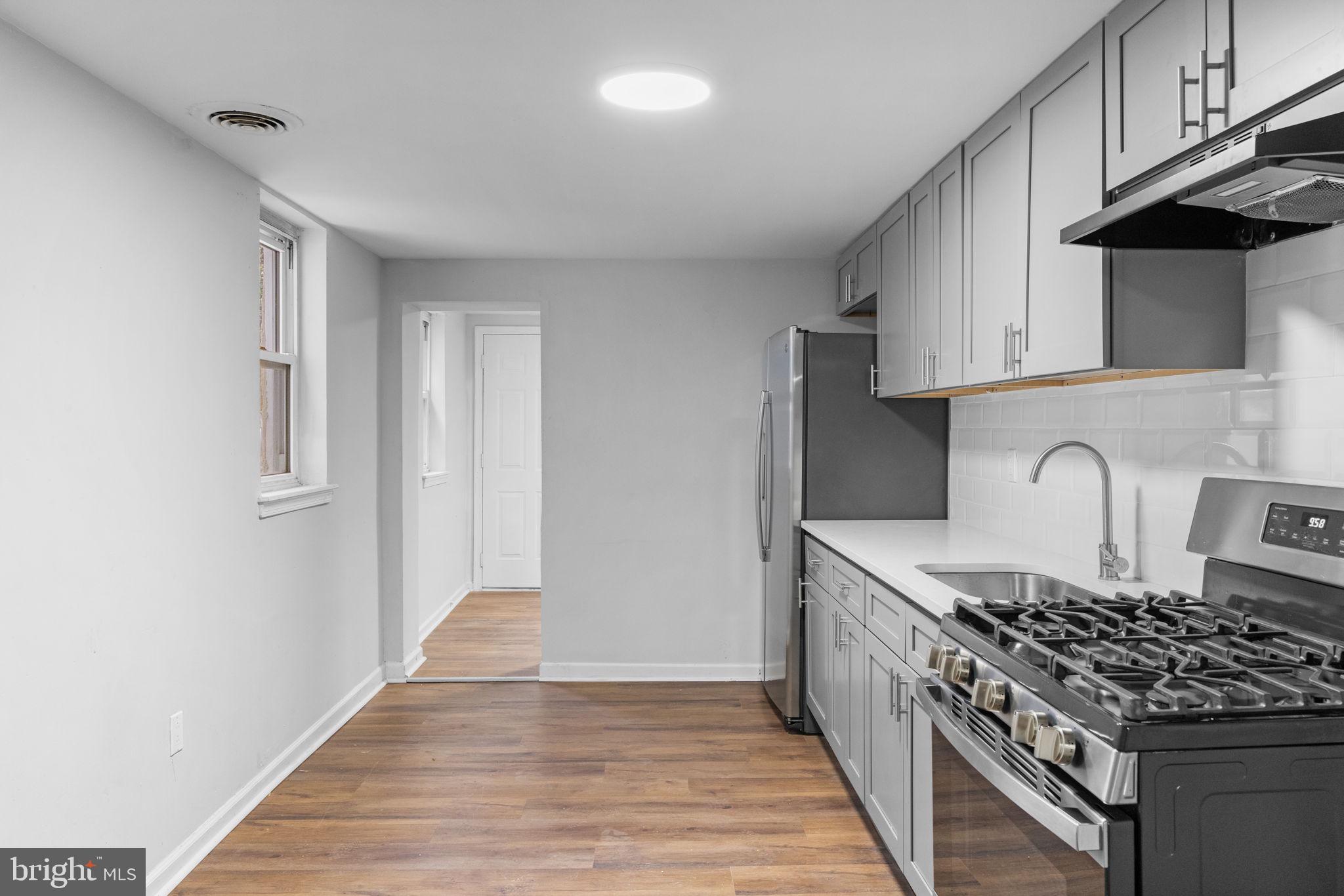 1020 Potter Street Chester, PA 19013 - Photo 7 of 26 a kitchen with granite countertop a stove and a sink
