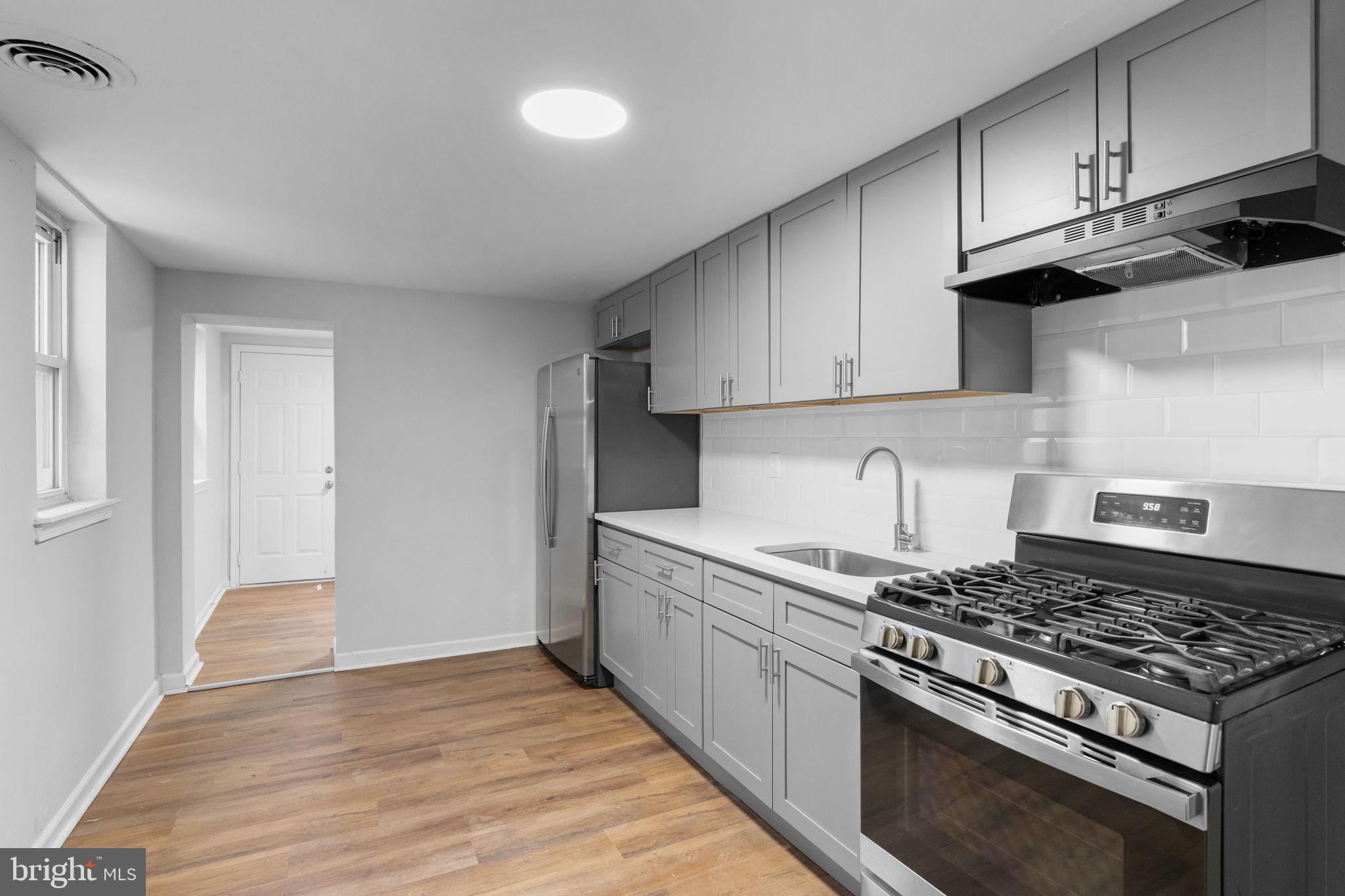 1020 Potter Street Chester, PA 19013 - Photo 8 of 26 a kitchen with stainless steel appliances granite countertop a stove and a wooden cabinets