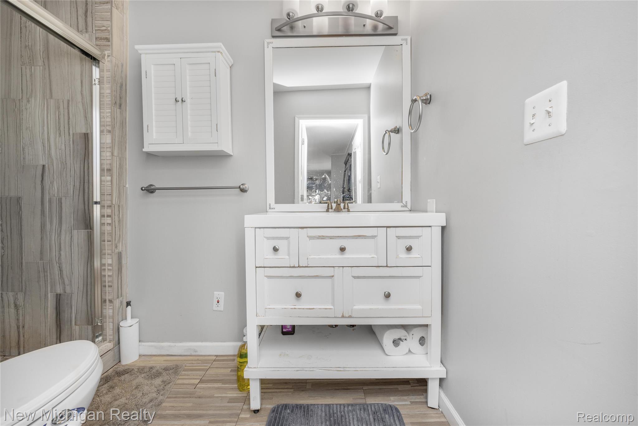 8665 Cooley Lake Road Commerce Township, MI 48382 - Photo 32 of 52 Full bath featuring vanity, a shower, and wood finish floors