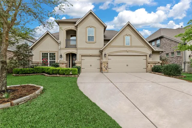 a view of a white house next to a yard and large trees